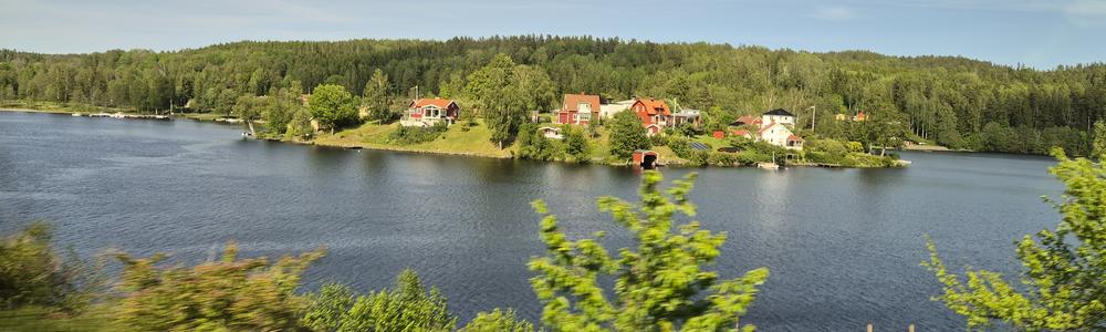 Röda stugor vid en sjö i skogskanten