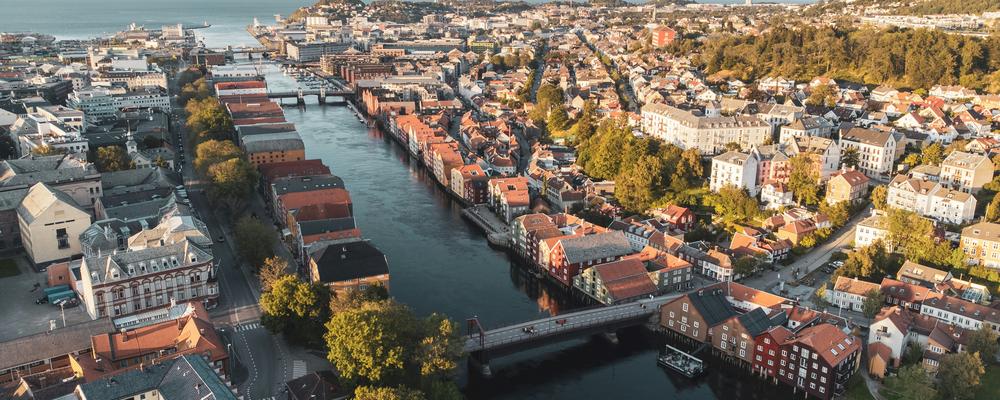 Flygbild över Trondheim med hus i stadsmiljö vid kanten av en å