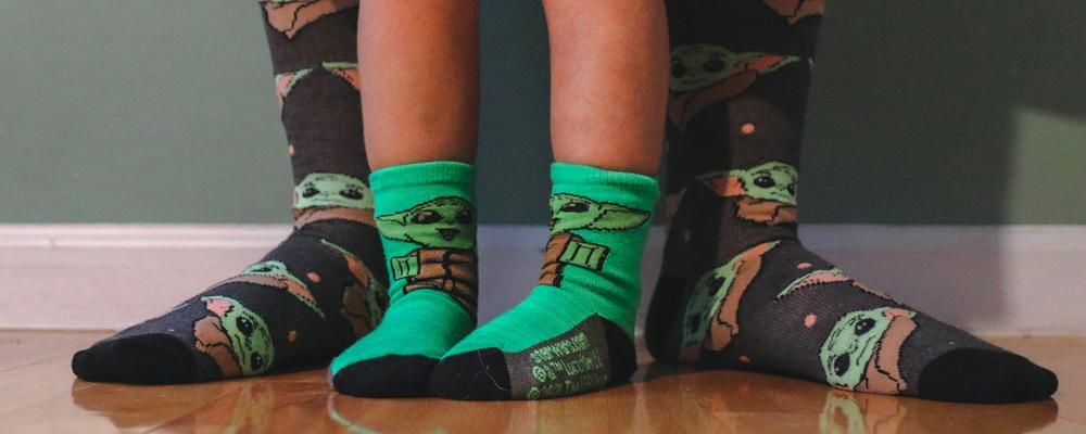 En vuxen och ett barn bär sockor