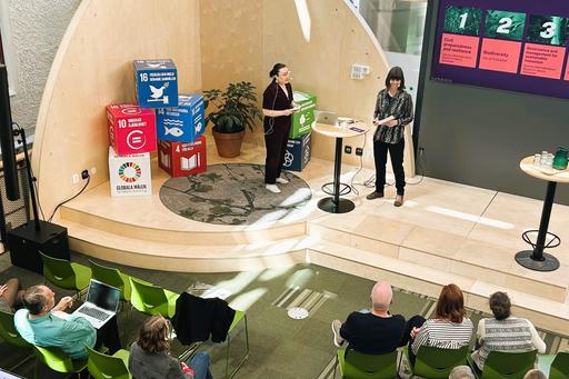 Bilden är från det evenemang där uppsatsklustren från 2024/2025 presenterades. Två personer står på en scen framför en publik.