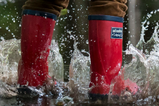Barn leker i vattenpöl.